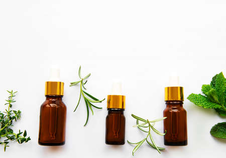 Aromatherapy concept, aroma oil and herbs - mint, rosemary, thyme on a white background, top viewの写真素材