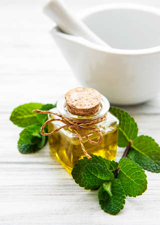 Essential aroma oil with mint on woodenの写真素材