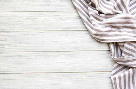 Beige folded kitchen cloth on wooden background, top view.の写真素材