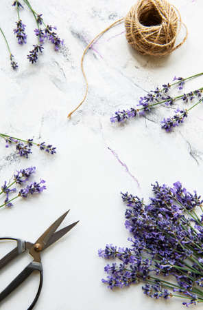 Lavender flowers, scissors and rope on a white marble backgroundの写真素材