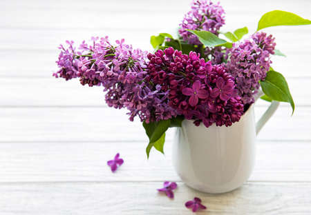 Spring bouquet. Luilac flowers in a vase on a white woodwn tableの写真素材