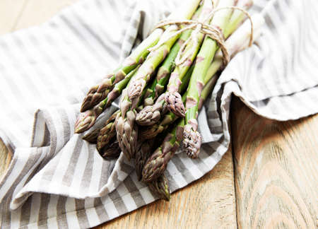 Fresh green asparagus on old wooden table. Flat layの写真素材