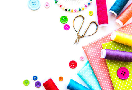 Sewing accessories and fabric on a white background. Sewing threads, needles, pins, fabric, buttons...