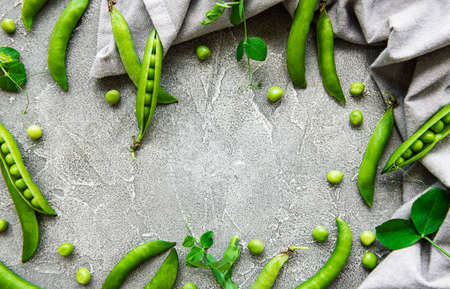 Pods of green peas on a concrete background. Organic food.の写真素材
