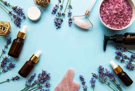 Natural organic SPA cosmetic with lavender. Flat lay bath salt, spa products and lavender flowers on blue background. Skin care, beauty treatment conceptの写真素材