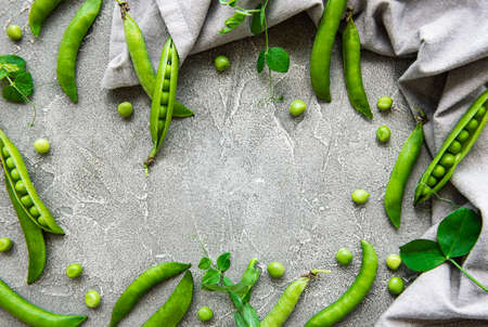 Pods of green peas on a concrete background. Organic food.の写真素材
