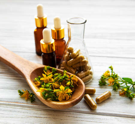 St. John's wort, herbal medical pills in test tube, bottles with natural oil on a tableの写真素材