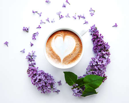Lilac flowers on a white background in the shape of a circle top view on a cup of coffeeの写真素材