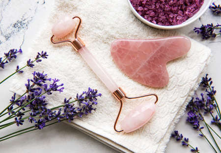 Set of natural organic SPA cosmetic with lavender. Flat lay bath salt and face roller, on marble...