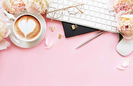 Flat lay top view women's office desk with flowers. Female workspace with laptop, flowers peonies,...