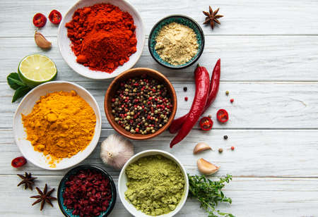 Various spices on white wooden background, top view