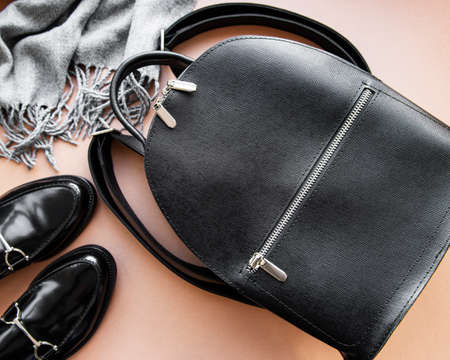 Women's black leather backpack, shoes and scarf. Women's leather fashion accessories. Flat lay, top...