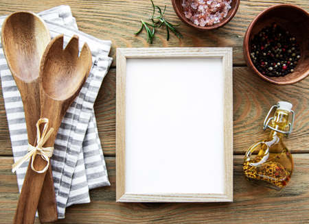 Old wooden kitchen utensils and spices with frame as a border on a old wooden backgroundの写真素材