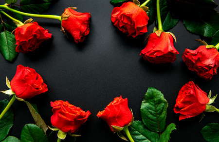 Red roses, concept of valentine day on a black background, top view.の写真素材