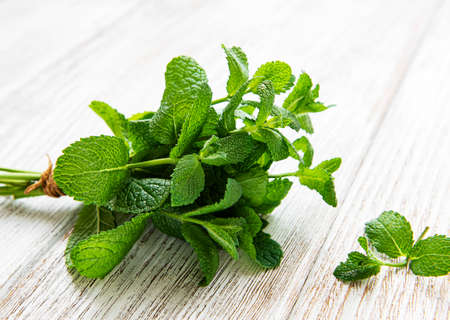 Fresh mint leaves on old wooden background, flat layの写真素材