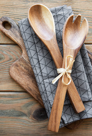 Old vintage kitchen utensils. Wooden spoons, cutting board, napkin over old wooden background. Top viewの写真素材