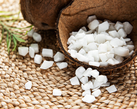 Dried sweet coconut cubes in bowl on wooden table background.の写真素材