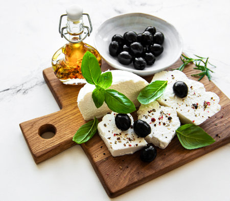 A fresh ricotta with basil leaves and olives on wooden board, italian food conceptの写真素材