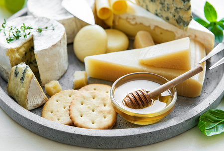 Various types of cheese, grapes and honey on a marble backgroundの写真素材