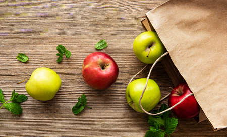 Fresh apples in a paper bag on a wooden backgroundの写真素材