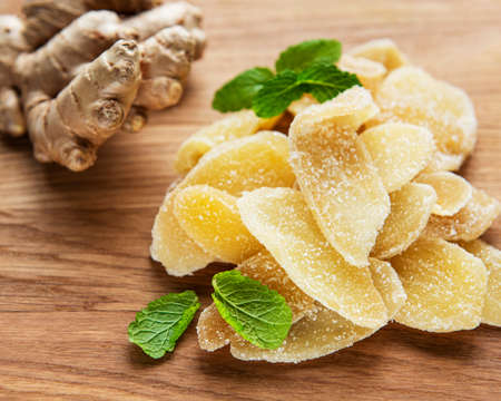 Sweet and spicy candied ginger on a old wooden tableの写真素材