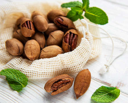 Pecan nuts in cotton bag on a wooden table
