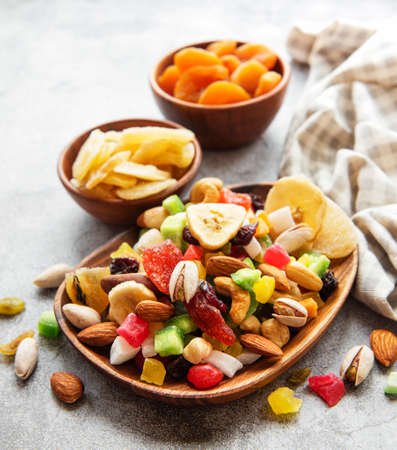Bowls with various dried fruits and nuts on a gray concrete backgroundの写真素材