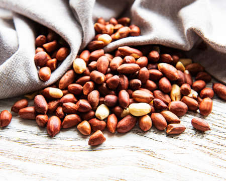 Peeled peanuts on a white wooden background