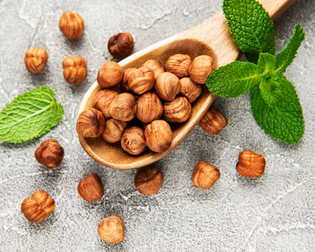 Peeled hazelnuts in a spoon on gray concrete backgroundの写真素材