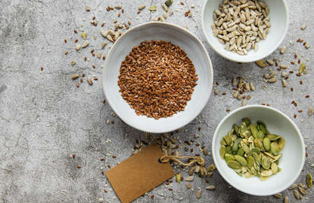 Mix different seeds for a healthy salad, bowls on a gray concrete backgroundの写真素材