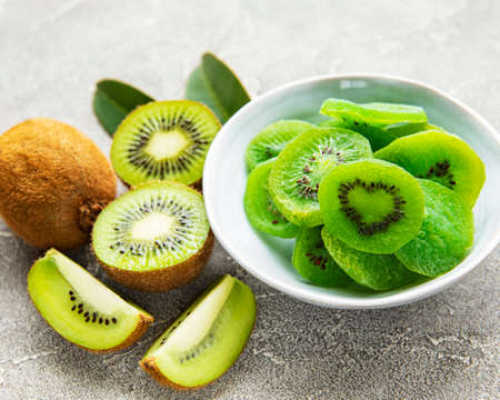 Pieces of dry kiwi in a bowl on a gray concrete backgroundの写真素材