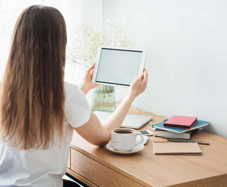 Young girl working at home office at the table