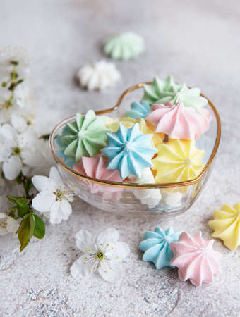 Small colorful meringues in the heart shaped bowl on concrete backgroundの写真素材