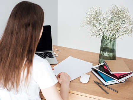Young girl working at home office at the table