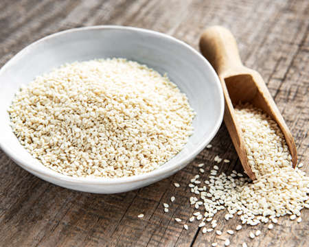 Healthy food and drink concept. Sesame seeds in a bowl on a rustic tableの写真素材