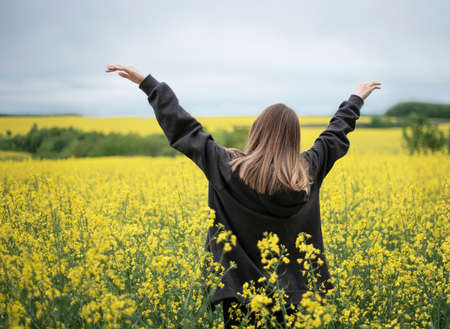 Young caucasian girl on yellow rapeseed field