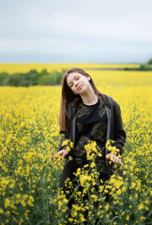Young caucasian girl on yellow rapeseed fieldの写真素材