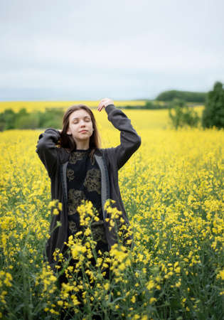 Young caucasian girl on yellow rapeseed fieldの写真素材