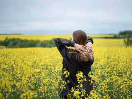 Young caucasian girl on yellow rapeseed field