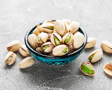 Bowl with pistachios on a gray concrete backgroundの写真素材