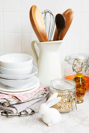 Kitchen utensils, tools and dishware on on the background white tile wall. Interior, modern kitchen...