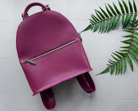 Burgundy women's backpack on gray tile, top view. Stylish accessory