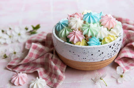Small colorful meringues in the ceramic bowl on tile backgroundの写真素材