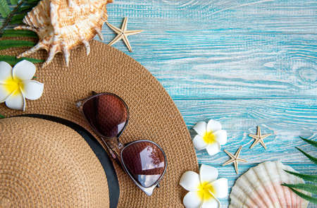 Summer vacation concept. Straw hat and beach accessories with seashells and starfish on blue wooden...
