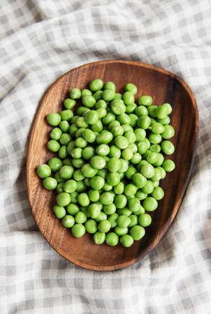 Fresh green peas pods and green peas with sprouts on textile background. Concept of healthy eating, fresh vegetables.の写真素材