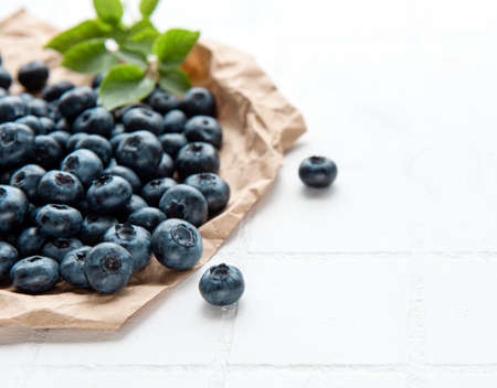 Freshly picked blueberries on a white tile background. Concept for healthy eating