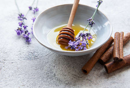 Bowl with honey and fresh lavender flowers on a concrete backgroundの写真素材