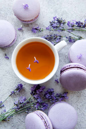 Cup of tea with lavender-flavored macaroon dessert and fresh lavender flowersの写真素材