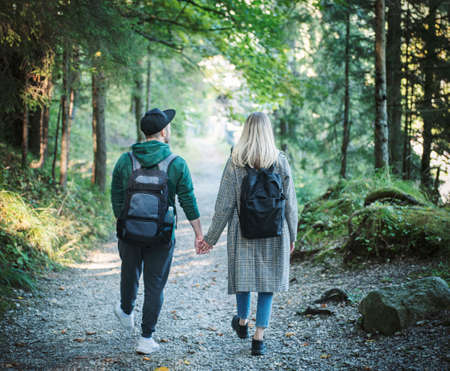 Traveler couple in love enjoying in the forest. Freedom and active lifestyle concept. Back viewの写真素材