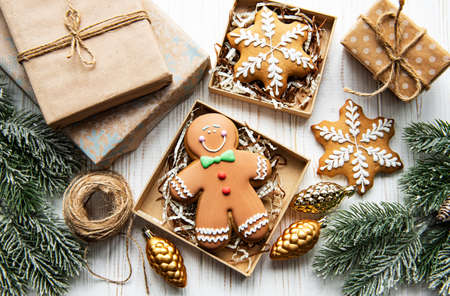 Christmas gingerbread cookies in cardboard boxes on white wooden table
